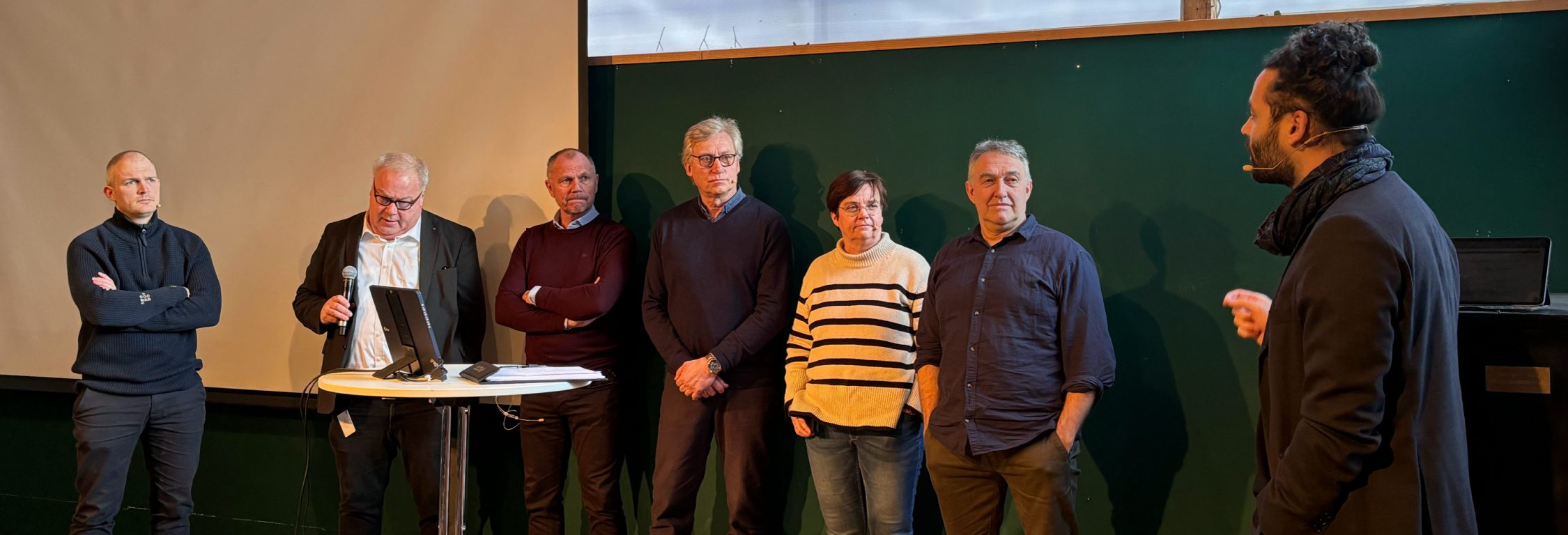 Paneldebatt med fem personer på et seminar.