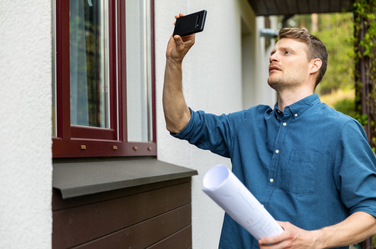 real estate appraiser taking pictures of property with phone